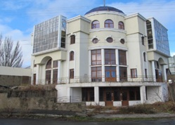 Адміністративна будівля, загальною площею 1 437,8 кв. м, за адресою: Херсонська обл., Генічеський р., м. Генічеськ, вулиця Центральна (Леніна), 1. Реєстраційний номер об’єкта нерухомого майна: 37841072. Інвентарний № 88986. Земельна ділянка, площею 0,1404 га (кадастровий номер 6522110100:01:006:0002), за адресою: Херсонська обл., Генічеський р., м. Генічеськ, вулиця Центральна (Леніна), 1. Цільове призначення - для розміщення адміністративного відділення Промінвестбанку. Інвентарний номер 74315. Аванс м. Генiчеськ, Херсон.обл., м. Генiчеськ, вул.Ленiна,1 на виконання робіт з/рах. 101 від 29.12.2009. Інвентарний номер 443043000023